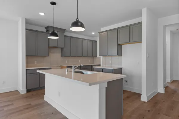 a kitchen with a sink a center island a stove and a refrigerator