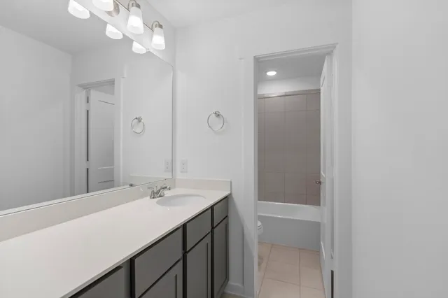 a bathroom with a sink a light fixture and a mirror