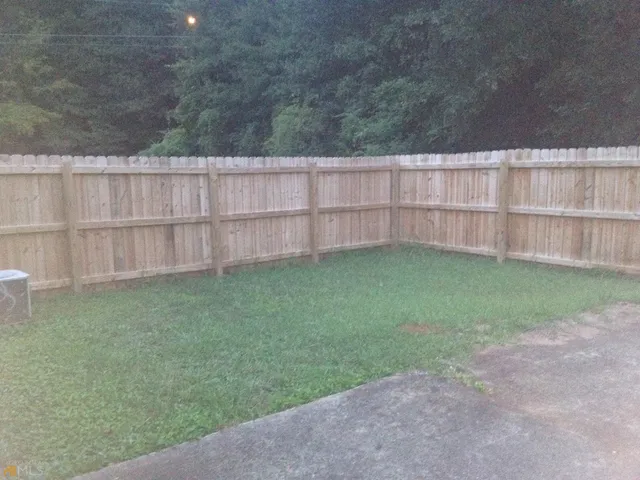 a view of a backyard with a wooden fence