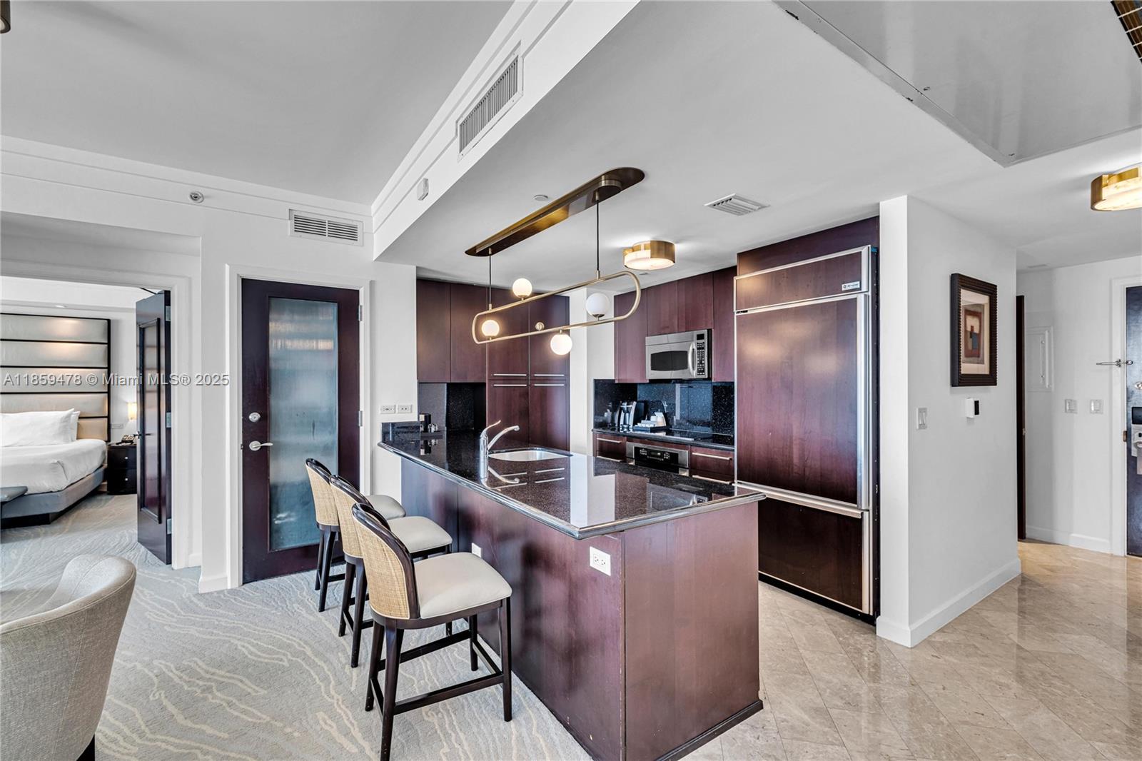 4391 Collins Avenue, Unit 1706/1707 Miami Beach, FL 33140 - Photo 46 of 50 a kitchen with stainless steel appliances kitchen island granite countertop a refrigerator a stove and a sink with dishwasher