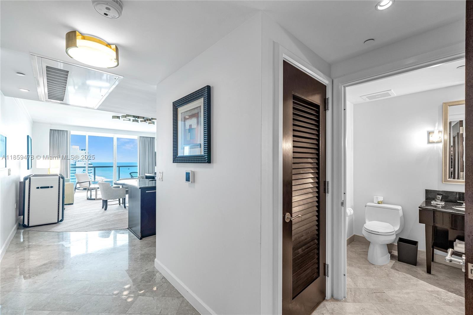 4391 Collins Avenue, Unit 1706/1707 Miami Beach, FL 33140 - Photo 47 of 50 a spacious bathroom with a toilet a sink and mirror