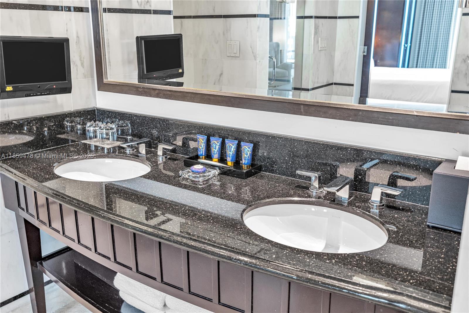 4391 Collins Avenue, Unit 1706/1707 Miami Beach, FL 33140 - Photo 48 of 50 a bathroom with a granite countertop double sink and a mirror