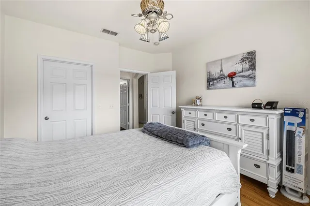 a bedroom with a bed and a chandelier