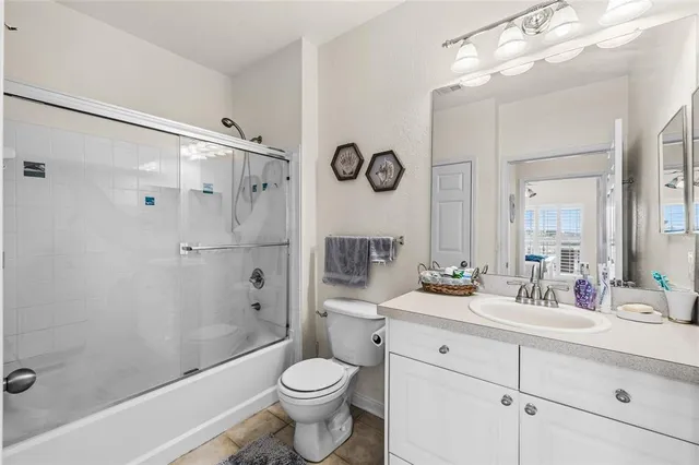 a bathroom with a double vanity sink toilet mirror and shower