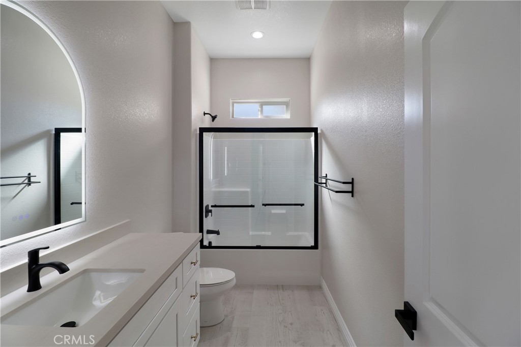 14785 Tigertail Road Apple Valley, CA 92307 - Photo 14 of 20 a bathroom with a toilet a sink and mirror