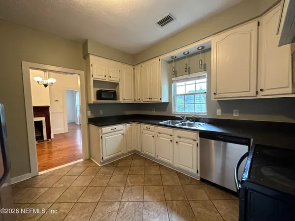 a kitchen with granite countertop a stove a sink and a microwave