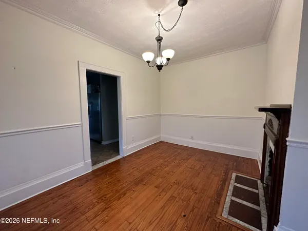 a view of empty room with wooden floor