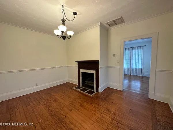 a view of a livingroom with wooden floor a ceiling fan and staircase