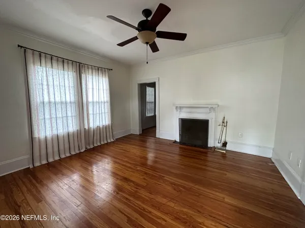 a view of empty room with wooden floor and fireplace