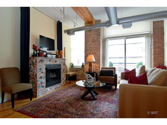 417 South Jefferson Street, Unit 202B Chicago, IL 60607 - Photo 2 of 8 a living room with furniture a fireplace and a large window