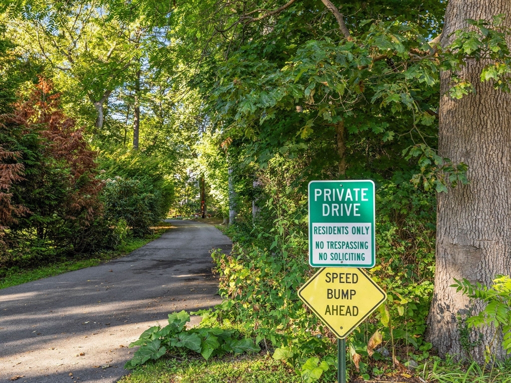 33 Boulder Road Wellesley, MA 02481 - Photo 5 of 6 a sign board with a bench and trees