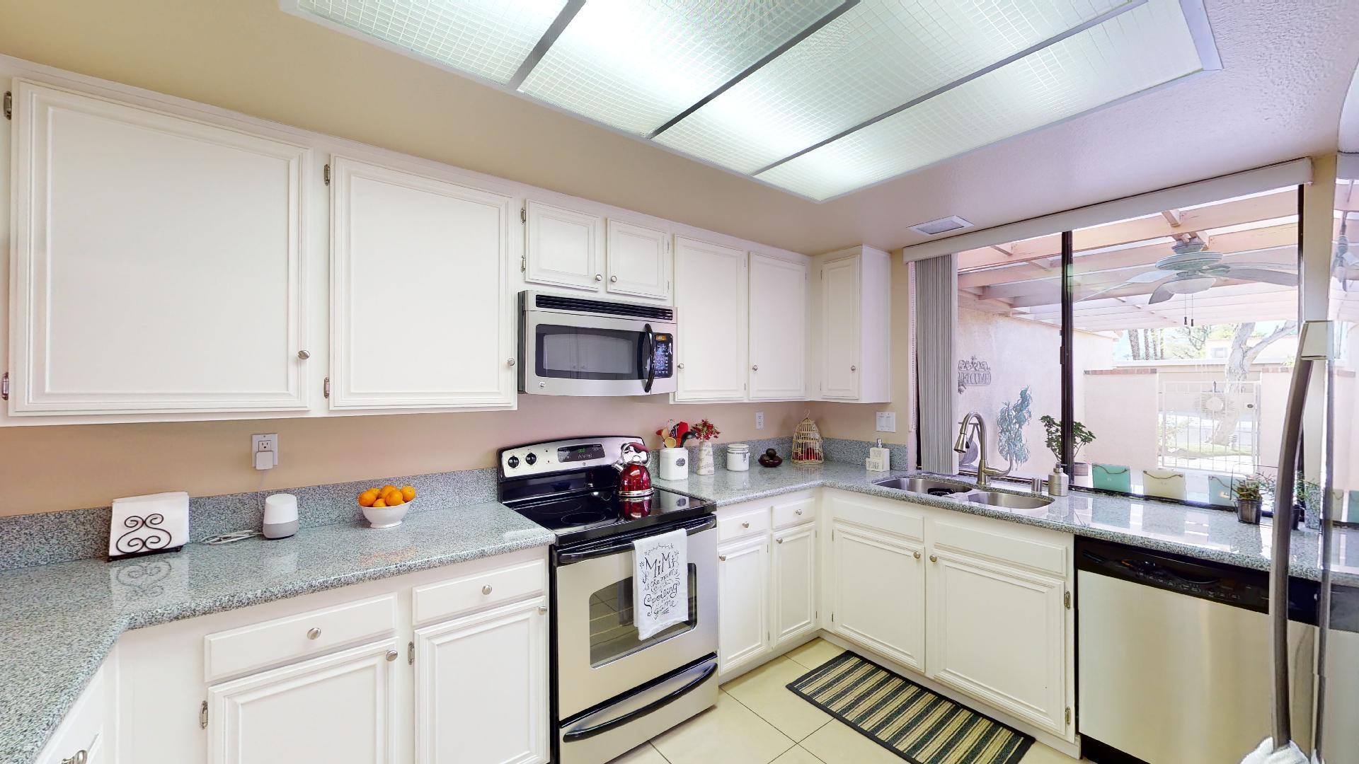 24 Granada Drive Rancho Mirage, CA 92270 - Photo 11 of 36 a kitchen with stainless steel appliances a sink a stove and white cabinets