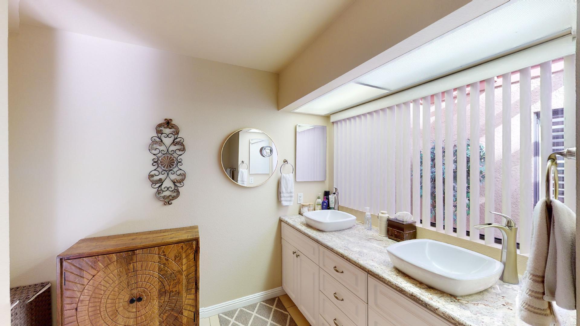 24 Granada Drive Rancho Mirage, CA 92270 - Photo 9 of 36 a bathroom with a granite countertop sink vanity mirror and a shower