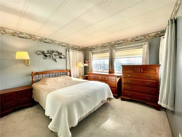 a bedroom with a bed and a dresser next to a window
