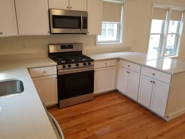 a kitchen with granite countertop a stove and a microwave
