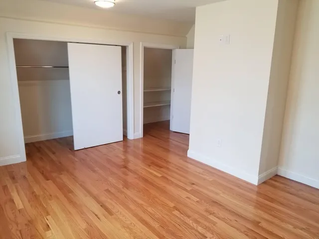 an empty room with wooden floor and closet