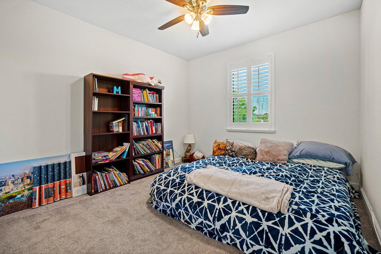 12949 Anthorne Lane Boynton Beach, FL 33436 - Photo 15 of 37 a bedroom with a bed furniture and a book shelf