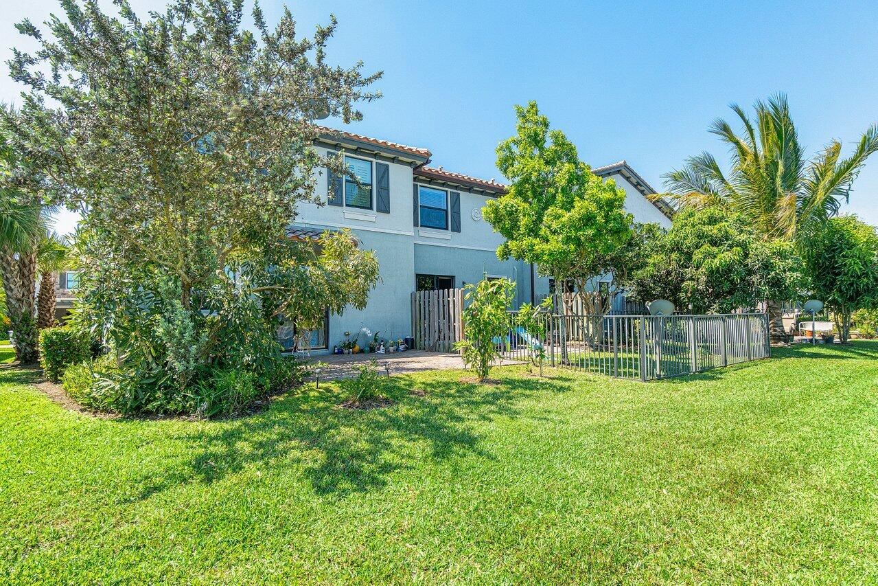 12949 Anthorne Lane Boynton Beach, FL 33436 - Photo 31 of 37 a backyard of a house with table and chairs