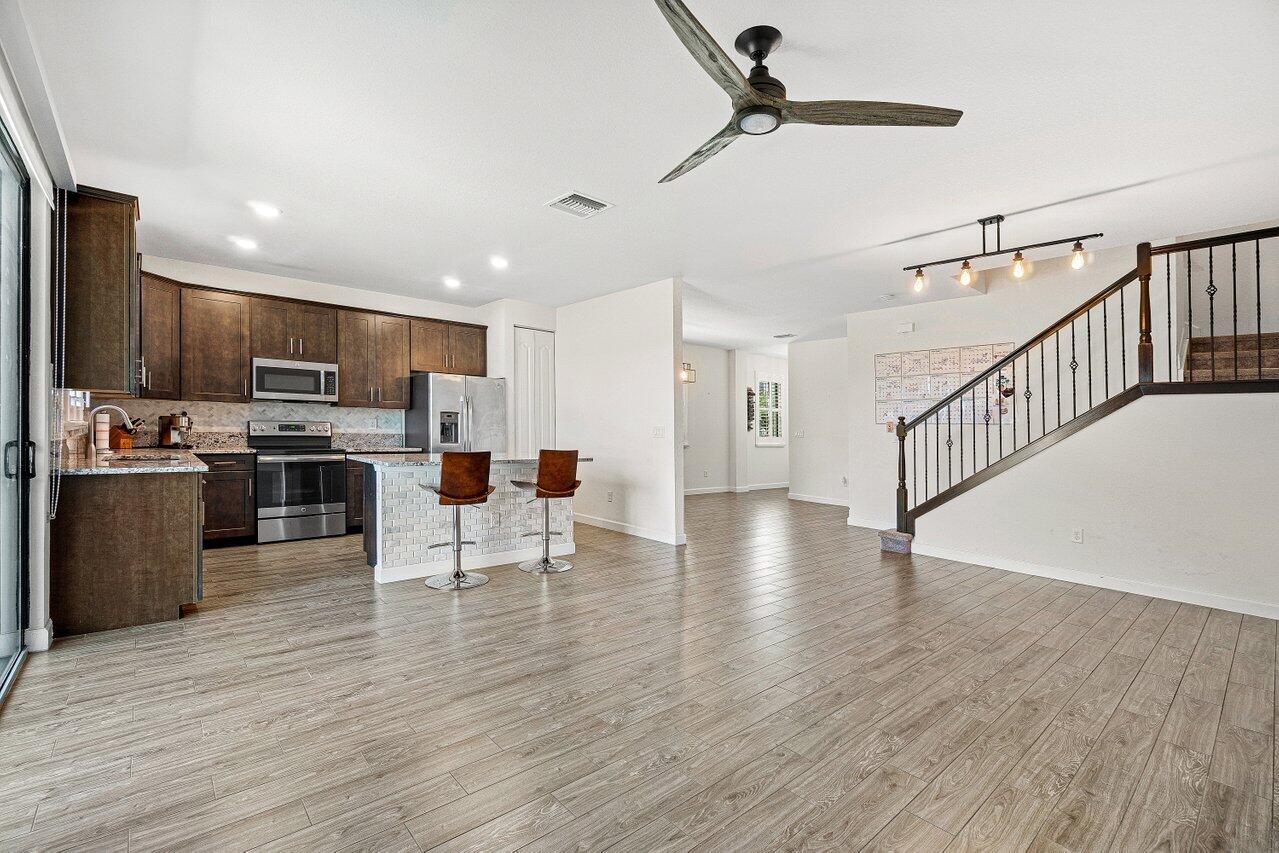 12949 Anthorne Lane Boynton Beach, FL 33436 - Photo 10 of 37 a view of kitchen with microwave stove refrigerator and wooden floor