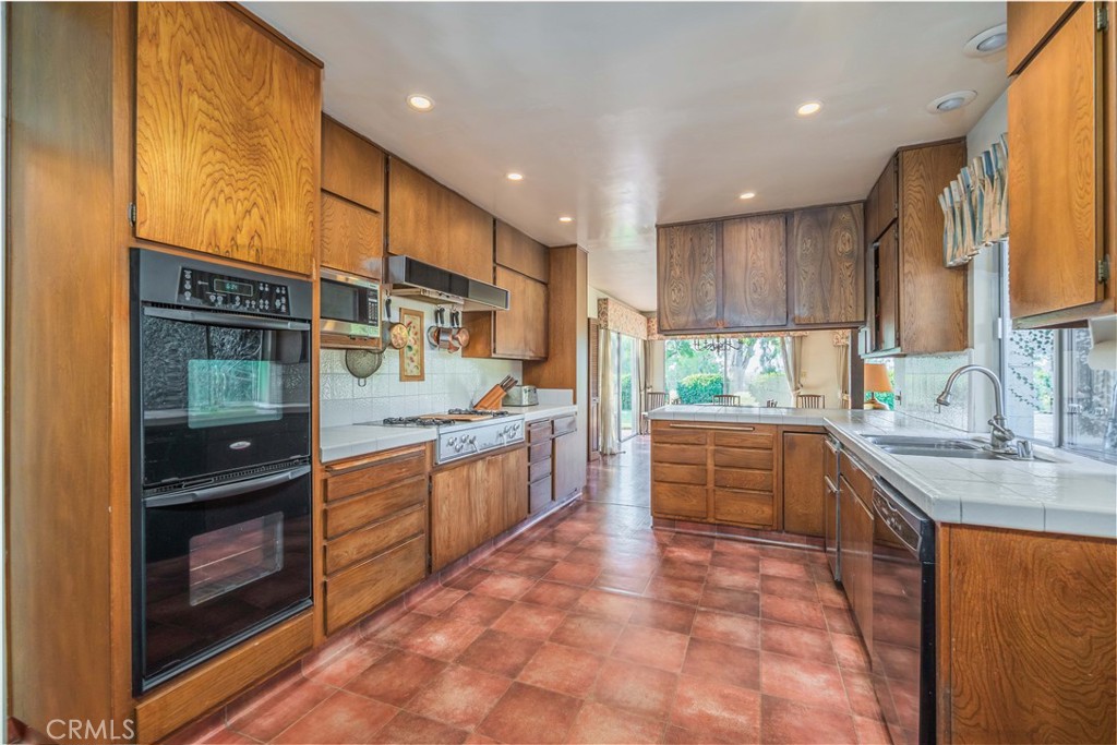 920 South Spring Meadow Drive West Covina, CA 91791 - Photo 12 of 48 a kitchen with stainless steel appliances granite countertop a sink and cabinets