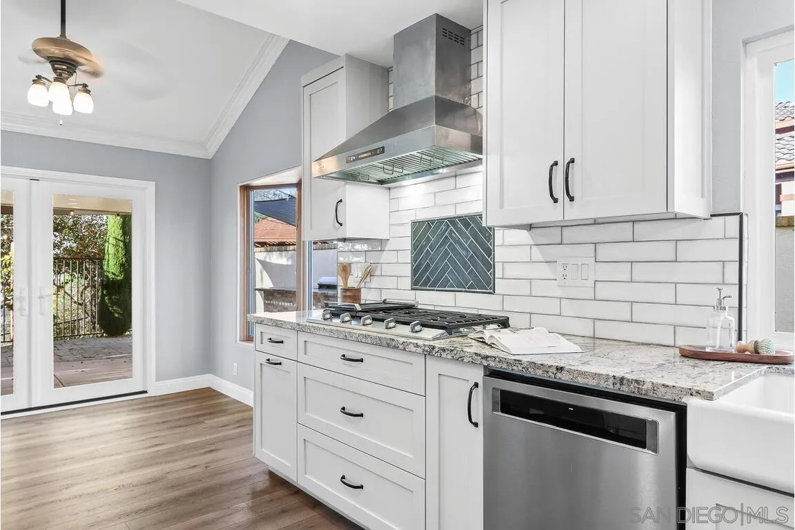 9160 Paseo Cresta Santee, CA 92071 - Photo 11 of 42 a kitchen with granite countertop a stove cabinets and wooden floor
