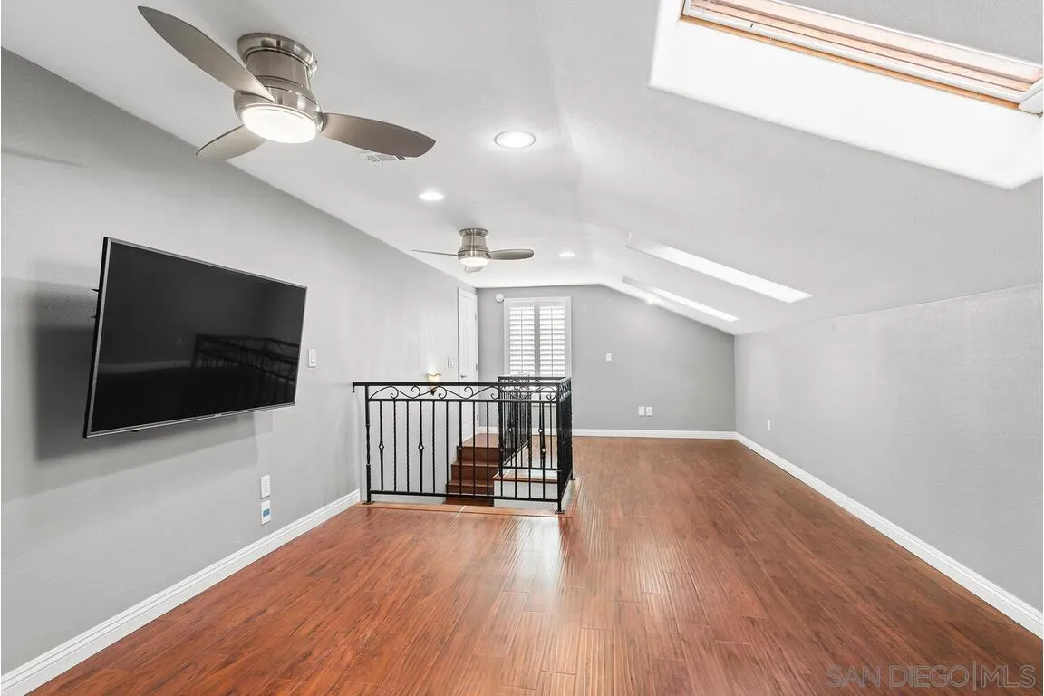 9160 Paseo Cresta Santee, CA 92071 - Photo 25 of 42 a view of a livingroom with wooden floor a ceiling fan and windows