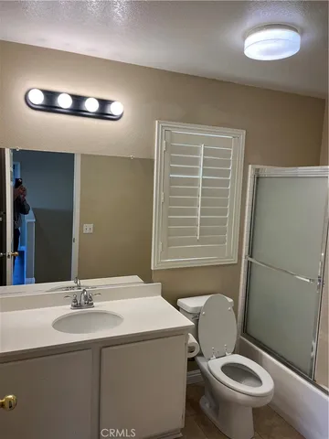 a bathroom with a sink mirror toilet and shower