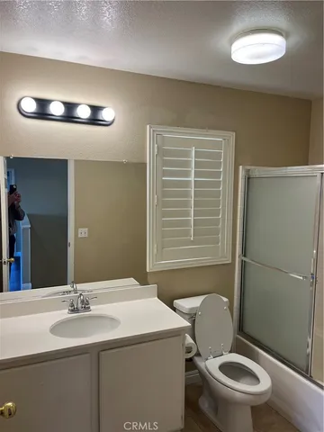 a bathroom with a toilet sink vanity and mirror