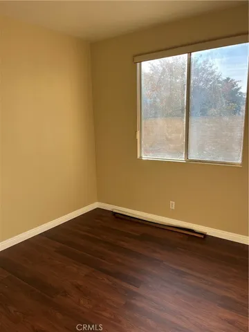 a view of a room with wooden floor and a window