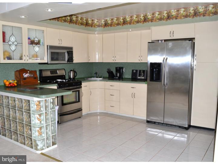 12023 Tyrone Road Philadelphia, PA 19154 - Photo 6 of 16 a kitchen with stainless steel appliances granite countertop a refrigerator a stove and a sink with wooden floor