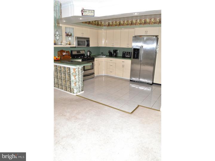 12023 Tyrone Road Philadelphia, PA 19154 - Photo 7 of 16 a kitchen with kitchen island cabinets and oven