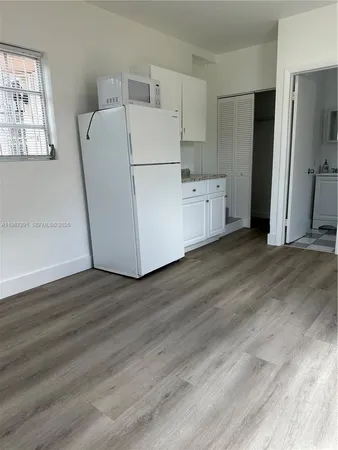 a view of a kitchen with wooden floor and electronic appliances
