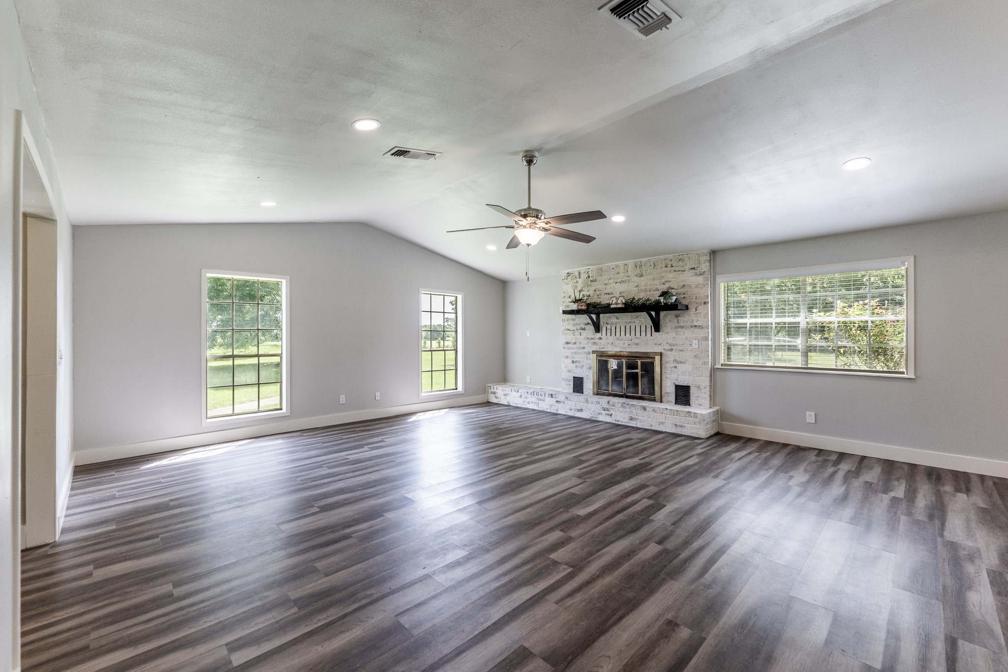 92 Mt Zion Road New Waverly, TX 77358 - Photo 4 of 33 an empty room with wooden floor windows and ceiling fan