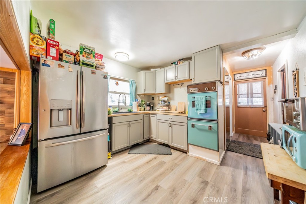 52647 Pine Cove Road Idyllwild, CA 92549 - Photo 16 of 35 a kitchen with granite countertop a refrigerator and a stove top oven