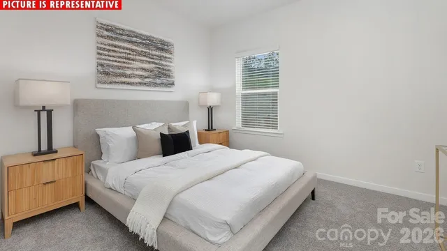 a large bed sitting in a bedroom next to a window