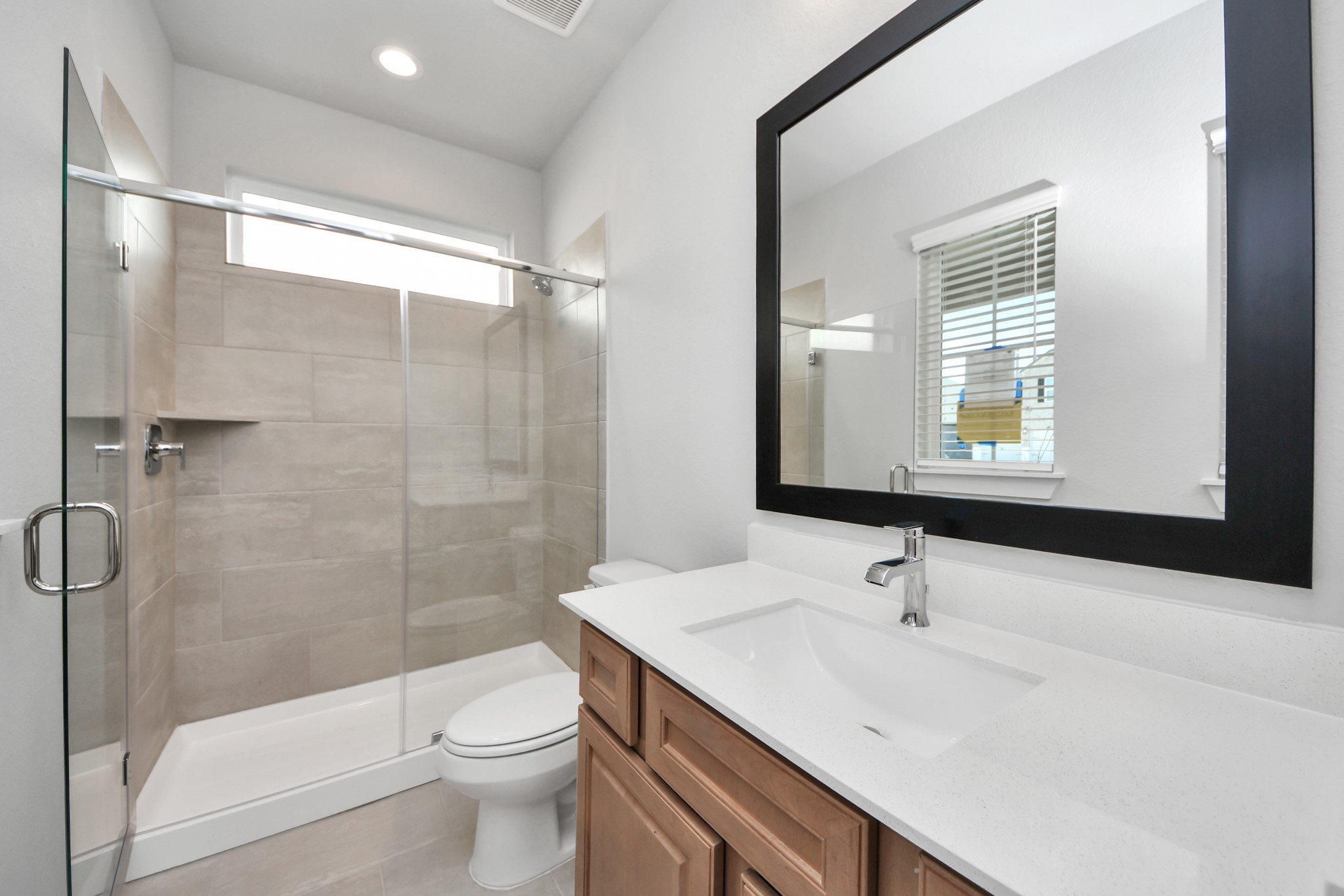 3102 Native Spg Drive Spring, TX 77373 - Photo 7 of 40 Secondary bath features tile flooring, walk-in shower tile surround, light stained wood cabinets, beautiful light countertop. Sample photo of completed home with similar floor plan. Actual colors and selections may vary.