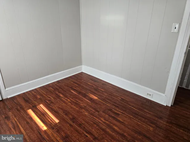 a view of wooden floor in a hall with a window