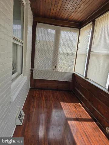 a view of room with wooden floor and windows