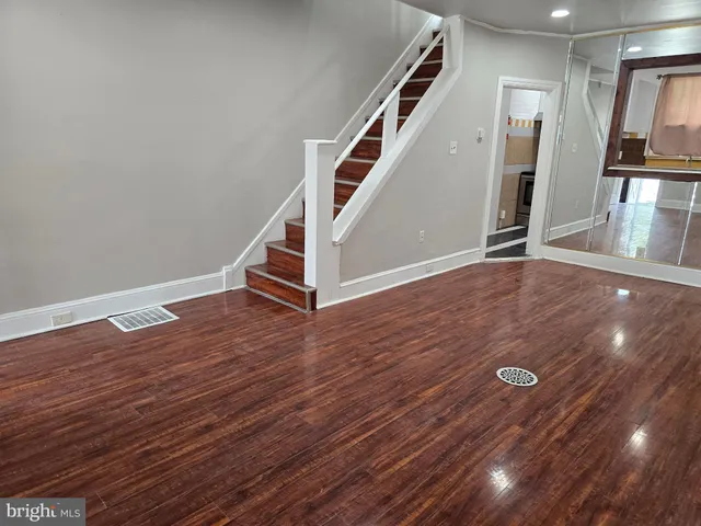 a view of a livingroom with wooden floor and stairs