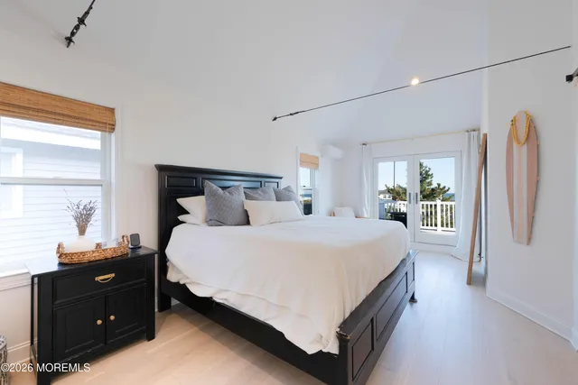 a bathroom with a double vanity sink a mirror a bathtub and next to a window