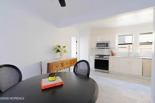 a kitchen with cabinets stainless steel appliances and wooden floor