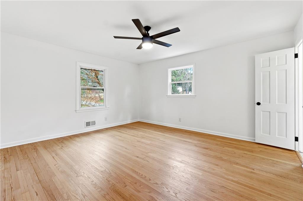 2520 Overlook Way Northeast Atlanta, GA 30345 - Photo 26 of 31 an empty room with wooden floor a ceiling fan and windows