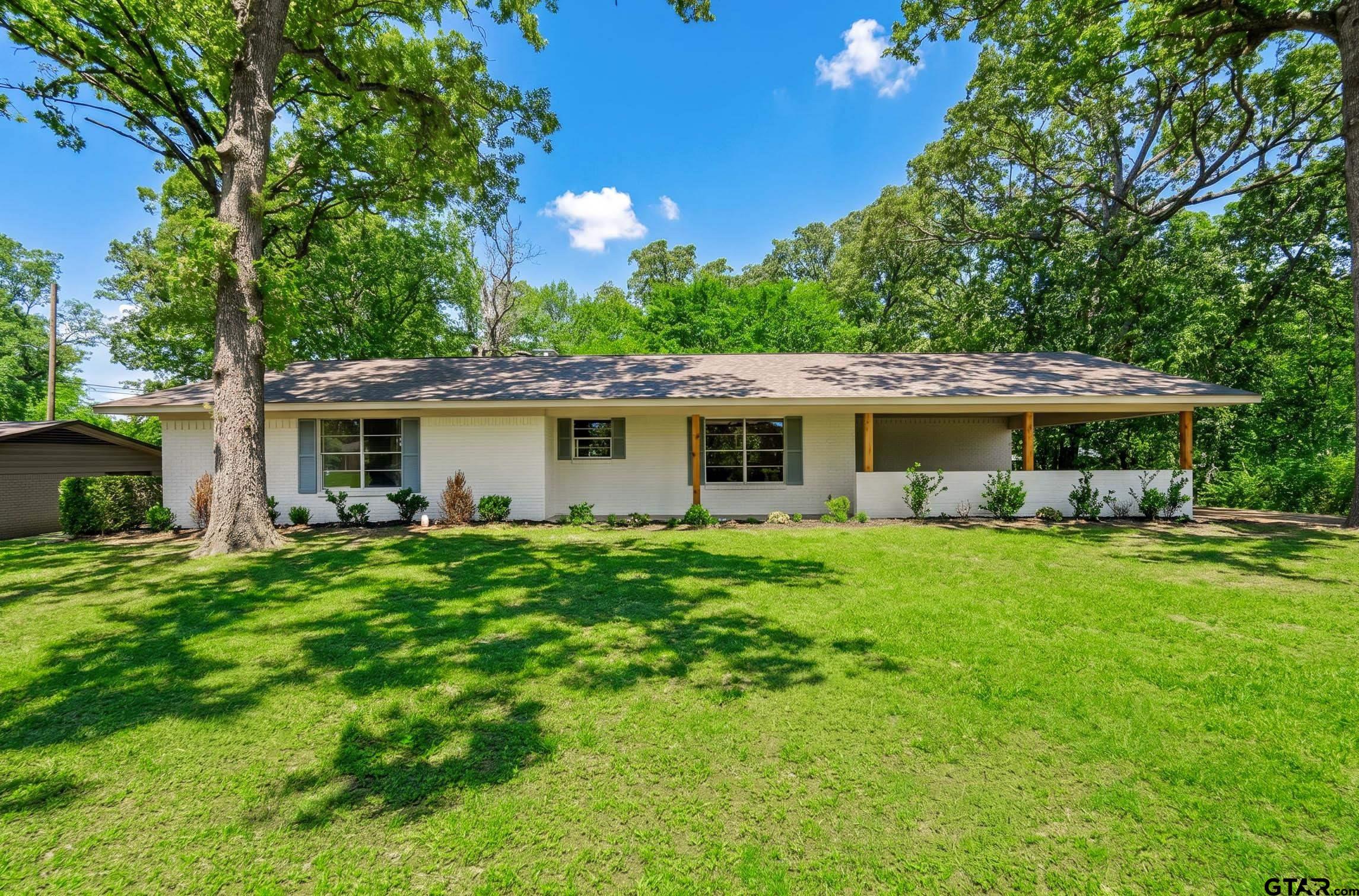 a front view of house with a garden