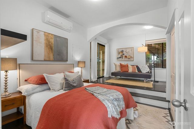 a bedroom with a bed and a large mirror on the dresser