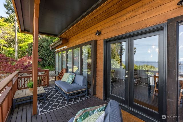 a view of a patio with table and chairs potted plants with wooden floor and floor to ceiling window