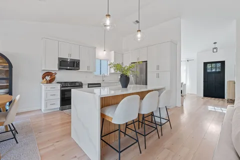 a living room with furniture a flat screen tv and a wooden floor
