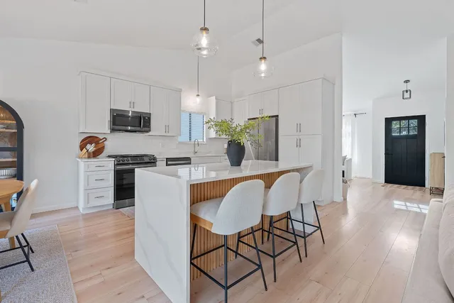 a living room with furniture a flat screen tv and a wooden floor