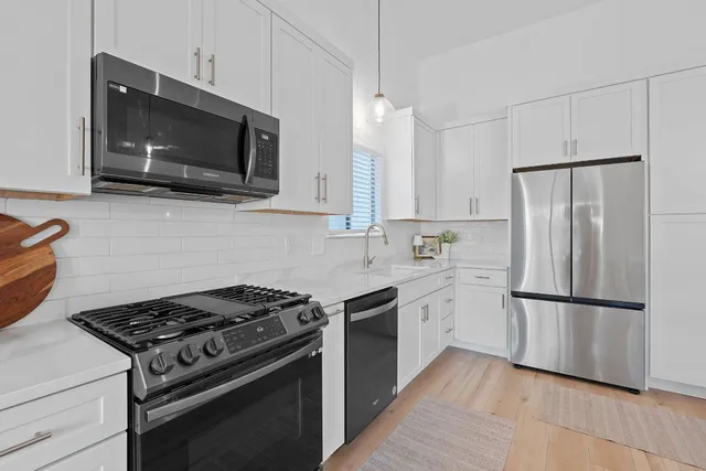 a kitchen with stainless steel appliances a refrigerator sink and microwave