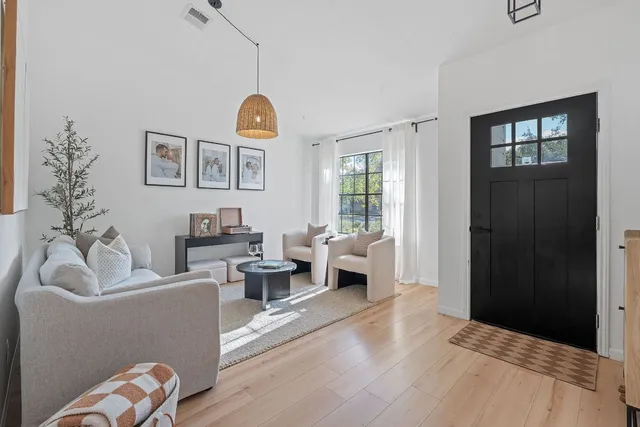 a kitchen with stainless steel appliances granite countertop a stove a sink dishwasher a dining table and chairs with wooden floor