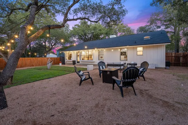 a view of a backyard with potted plants and a large tree